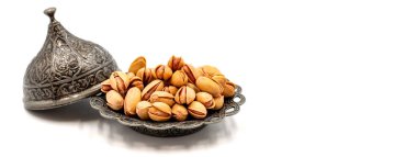 Kabuklu fıstıklar beyaz arka planda izole edilmiş. Köy servis tabağında şam fıstığı. Uzayı kopyala Metin alanı için boşluk