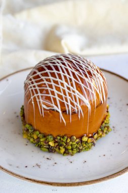 Beyaz arka planda New York turtası. New York Kek Çileği, Muz, Ahududu, Fıstık, Karamel, Çikolata Sosu hazır. Kapat.