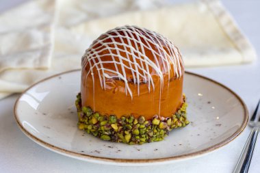 Beyaz arka planda New York turtası. New York Kek Çileği, Muz, Ahududu, Fıstık, Karamel, Çikolata Sosu hazır. Kapat.