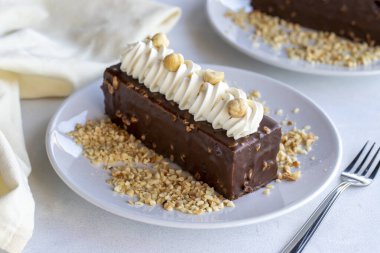 Beyaz arka planda fındıklı çikolatalı pasta. Kapat.