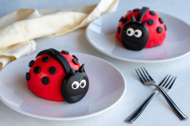 Beyaz arka planda uğur böceği pastası tasarımı. Kapat.