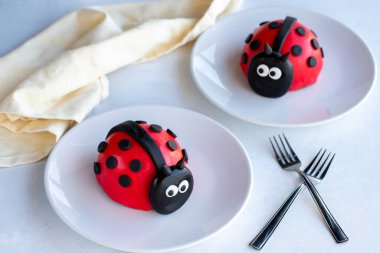 Beyaz arka planda uğur böceği pastası tasarımı. Kapat.