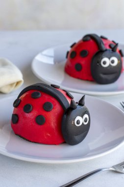 Beyaz arka planda uğur böceği pastası tasarımı. Kapat.