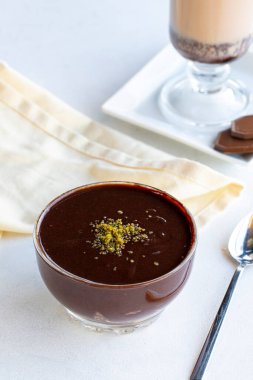 Çikolatalı puding ya da beyaz arka planda süper tatlı. Yanında sıcak çikolatayla. Kapat.