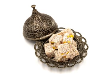 Beyaz arka planda şam fıstıklı Türk lokumu. Kapat.