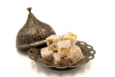 Beyaz arka planda şam fıstıklı Türk lokumu. Kapat.