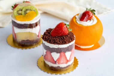 Beyaz arka planda meyveli çeşitli mini kekler. Kapat.