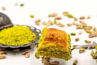 Çatalla çatallı, beyaz arka planda fıstıklı baklava. Geleneksel Türk mutfağı lezzetleri. Yakın plan Pistachio Baklava. Yerel adı kuru baklava