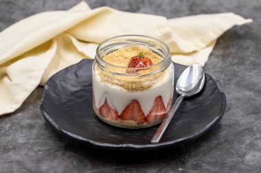 Koyu arkaplanda çilekli manolya tatlısı. Dünya mutfağı lezzetleri. Kapat.