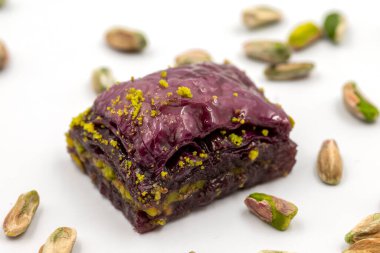 Beyaz arka planda Pistachio mor baklavası. Baklava şeker hastaları için özel olarak hazırlandı. Geleneksel Akdeniz mutfağı lezzetleri. Kapat.
