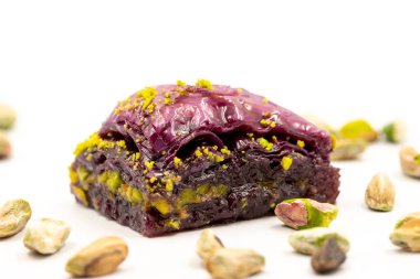 Beyaz arka planda Pistachio mor baklavası. Baklava şeker hastaları için özel olarak hazırlandı. Geleneksel Akdeniz mutfağı lezzetleri. Kapat.