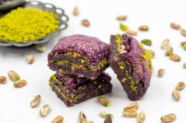 Beyaz arka planda Pistachio mor baklavası. Baklava şeker hastaları için özel olarak hazırlandı. Geleneksel Akdeniz mutfağı lezzetleri. Kapat.
