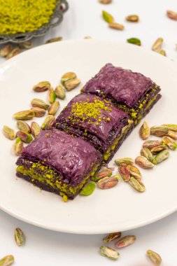 Beyaz arka planda Pistachio mor baklavası. Baklava şeker hastaları için özel olarak hazırlandı. Geleneksel Akdeniz mutfağı lezzetleri. Kapat.