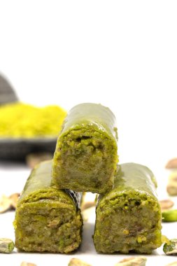 Beyaz arka planda fıstıkla kaplanmış baklava. Geleneksel Akdeniz mutfağı lezzetleri. Yakın plan şam fıstıklı baklava. yerel adı fistik sarma baklava