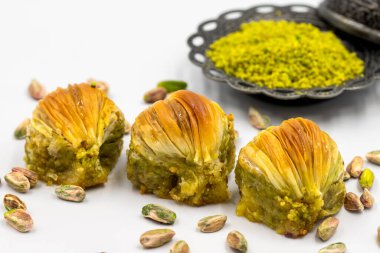 Beyaz arka planda midye baklavası. Geleneksel Akdeniz mutfağı lezzetleri. Yakın plan şam fıstıklı baklava. yerel adı Midye Baklava