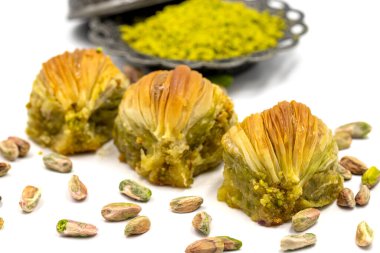 Beyaz arka planda midye baklavası. Geleneksel Akdeniz mutfağı lezzetleri. Yakın plan şam fıstıklı baklava. yerel adı Midye Baklava