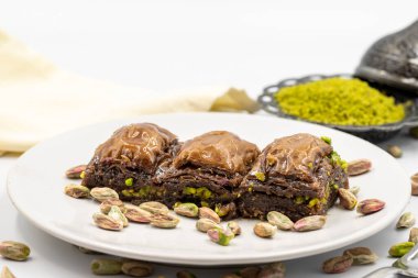 Beyaz arka planda fıstıklı çikolatalı baklava. Geleneksel Akdeniz mutfağı lezzetleri. Çikolatalı Baklava 'ya yakın çekim. Yerel adı cthe baklava