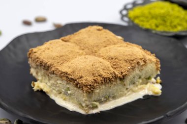 Beyaz arka planda soğuk baklava. Süt ve şam fıstığı ile hazırlanmış soğuk baklava çok popülerdir. Geleneksel Akdeniz mutfağı lezzetleri. Yakın plan soğuk baklava. yerel adı soguk baklava