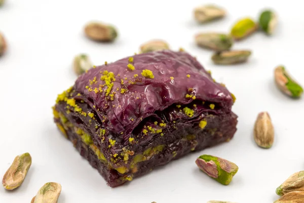 Beyaz arka planda Pistachio mor baklavası. Baklava şeker hastaları için özel olarak hazırlandı. Geleneksel Akdeniz mutfağı lezzetleri. Kapat.