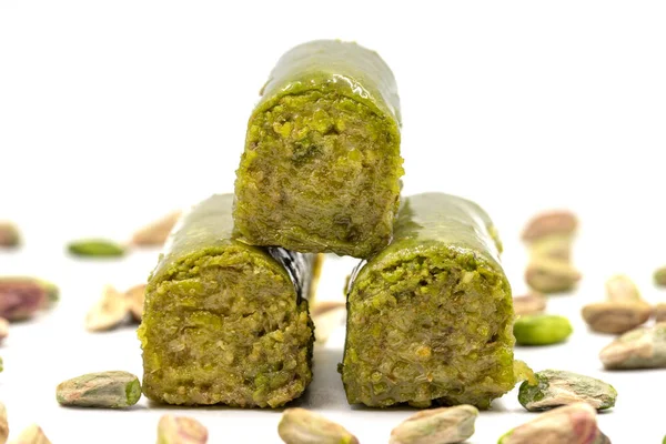 Beyaz arka planda fıstıkla kaplanmış baklava. Geleneksel Akdeniz mutfağı lezzetleri. Yakın plan şam fıstıklı baklava. yerel adı fistik sarma baklava