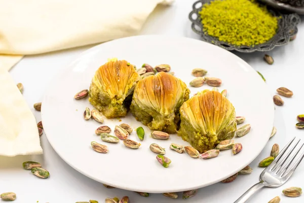 Beyaz arka planda midye baklavası. Geleneksel Akdeniz mutfağı lezzetleri. Yakın plan şam fıstıklı baklava. yerel adı Midye Baklava