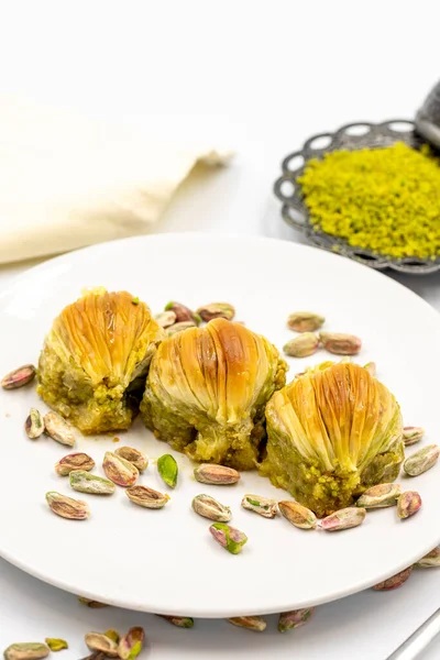 Beyaz arka planda midye baklavası. Geleneksel Akdeniz mutfağı lezzetleri. Yakın plan şam fıstıklı baklava. yerel adı Midye Baklava
