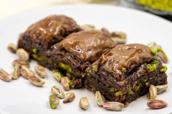 Beyaz arka planda fıstıklı çikolatalı baklava. Geleneksel Akdeniz mutfağı lezzetleri. Çikolatalı Baklava 'ya yakın çekim. Yerel adı cthe baklava