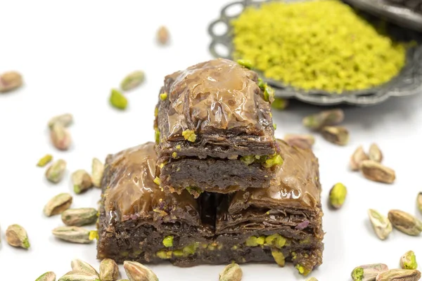 Beyaz arka planda fıstıklı çikolatalı baklava. Geleneksel Akdeniz mutfağı lezzetleri. Çikolatalı Baklava 'ya yakın çekim. Yerel adı cthe baklava