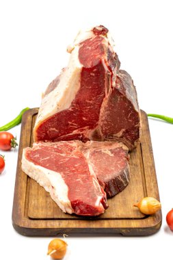 Kurumuş Raw T-bone ya da biftekli biftek, domates ve biberli biftek. Beyaz arka plan. Kapat.
