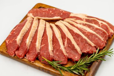 Beyaz arka planda sığır eti filetosu izole edilmiş. Tahta servis tahtasına çiğ sığır filetosu. Kapat.