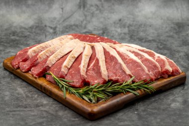 Karanlık bir arka planda biftek fileto. Tahta servis tahtasına çiğ sığır filetosu. Kapat.