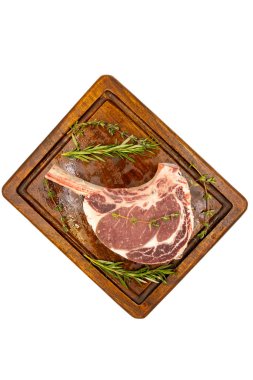 Beyaz arka planda çiğ dana pirzolası izole edilmiş. Tahta servis tahtasında çiğ dana pirzolası. Üst Manzara. Kapat.