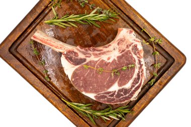 Beyaz arka planda çiğ dana pirzolası izole edilmiş. Tahta servis tahtasında çiğ dana pirzolası. Üst Manzara. Kapat.