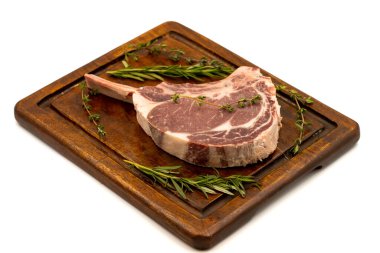 Beyaz arka planda çiğ dana pirzolası izole edilmiş. Çiğ dana pirzolası servis tahtası. Kapat.