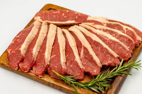 Beyaz arka planda sığır eti filetosu izole edilmiş. Tahta servis tahtasına çiğ sığır filetosu. Kapat.