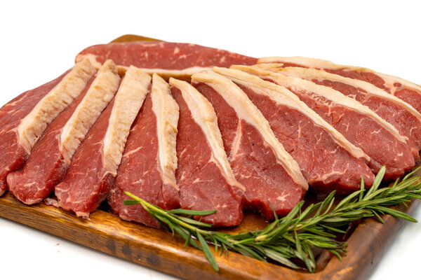 Beef fillet isolated on a white background. Raw beef tenderloin on wooden serving board. close up
