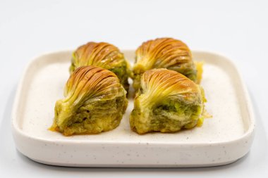 Midye baklavası. Beyaz arka planda Pistachio baklava izole edilmiş. Akdeniz mutfağı lezzetlidir. Yakın plan. yerel adı Midye Baklava