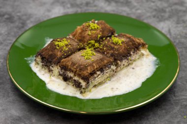 Koyu çikolata baklavası. Siyah arka planda süt olan baklava. Akdeniz mutfağı lezzetlidir. Yakın plan. Yerel adı: Acı soguk baklava