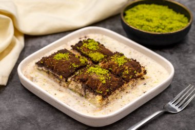 Koyu çikolata baklavası. Siyah arka planda süt olan baklava. Akdeniz mutfağı lezzetlidir. Yakın plan. Yerel adı: Acı soguk baklava