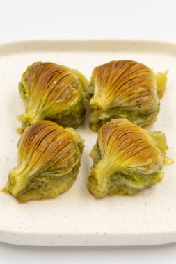 Midye baklavası. Beyaz arka planda Pistachio baklava izole edilmiş. Akdeniz mutfağı lezzetlidir. Yakın plan. yerel adı Midye Baklava