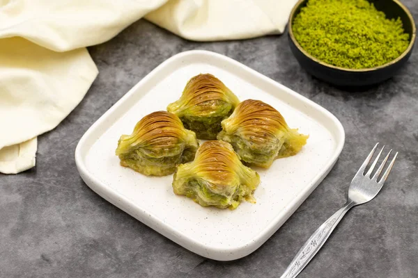 Midye baklavası. Fıstıklı baklava, koyu bir arka planda. Akdeniz mutfağı lezzetlidir. Yakın plan. yerel adı Midye Baklava