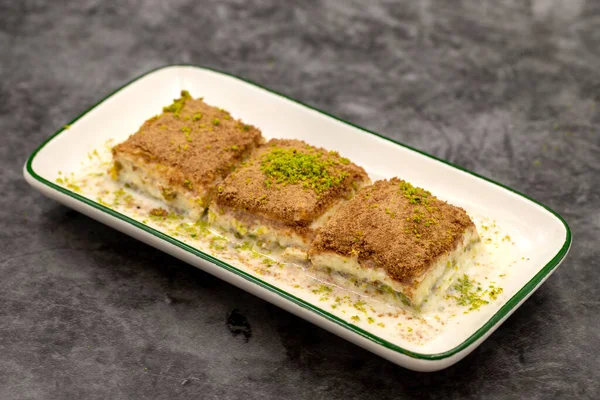 Soğuk baklava. Siyah arka planda süt olan baklava. Akdeniz mutfağı lezzetlidir. Yakın plan. Yerel adı soguk baklava