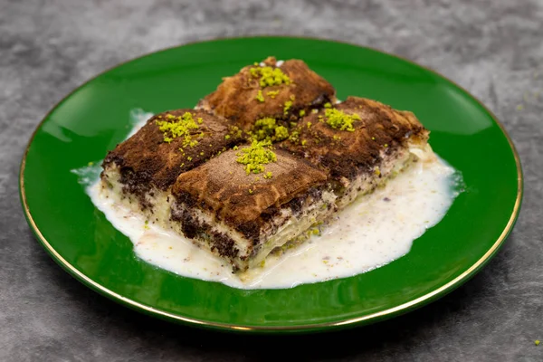Koyu çikolata baklavası. Siyah arka planda süt olan baklava. Akdeniz mutfağı lezzetlidir. Yakın plan. Yerel adı: Acı soguk baklava