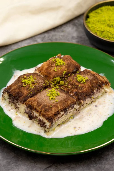 Koyu çikolata baklavası. Siyah arka planda süt olan baklava. Akdeniz mutfağı lezzetlidir. Yakın plan. Yerel adı: Acı soguk baklava