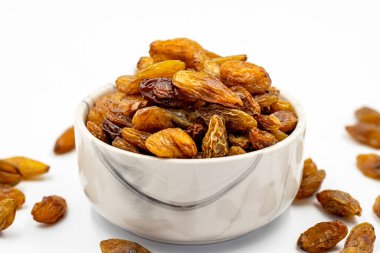 Beyaz arka planda kuru üzümler. Çiğ üzüm ve kuru üzüm. Sağlıklı ve taze fındık. Yakın plan. Yerel adı besni uzum