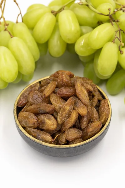Beyaz arka planda kuru üzümler. Çiğ üzüm ve kuru üzüm. Sağlıklı ve taze fındık. Yakın plan. Yerel adı besni uzum