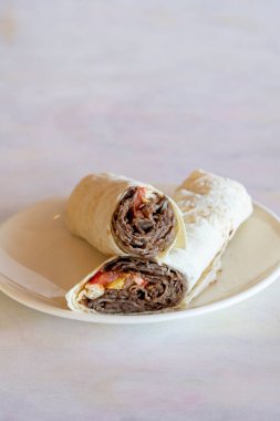 Shawarma; ızgara kuzu kebabı Yoğurt, turşu, soğan, patlıcan ve domates ile sarma.