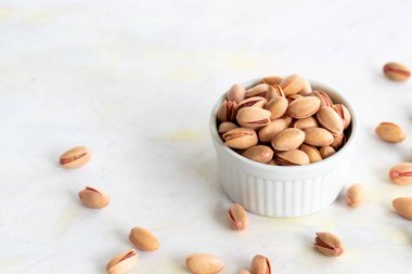 Fıstıklar - beyaz ahşap arka planda