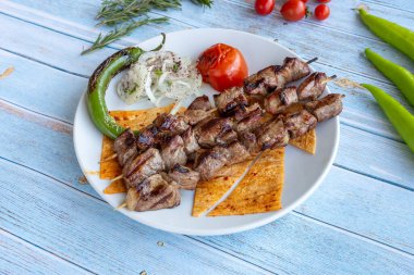 Asya tarzı mavi arka plan, üstten görünüm üzerinde sığır eti şiş ızgara. Lezzetli meze, tapas, snack