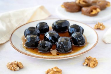 Beyaz ahşap arka planda reçelli ceviz sergisi, sağlıklı yiyecekler. - ceviz tatlisi - ceviz receli